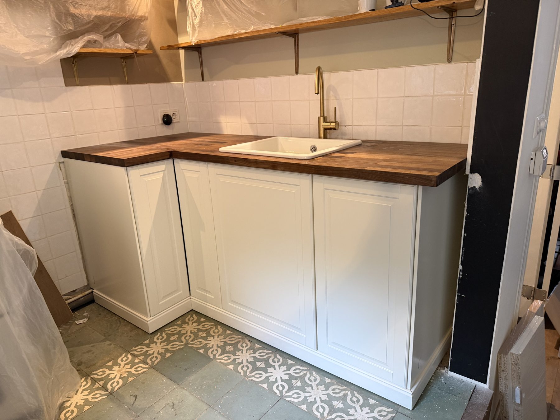 Landelijke witte keuken met houten werkblad en messing kraan